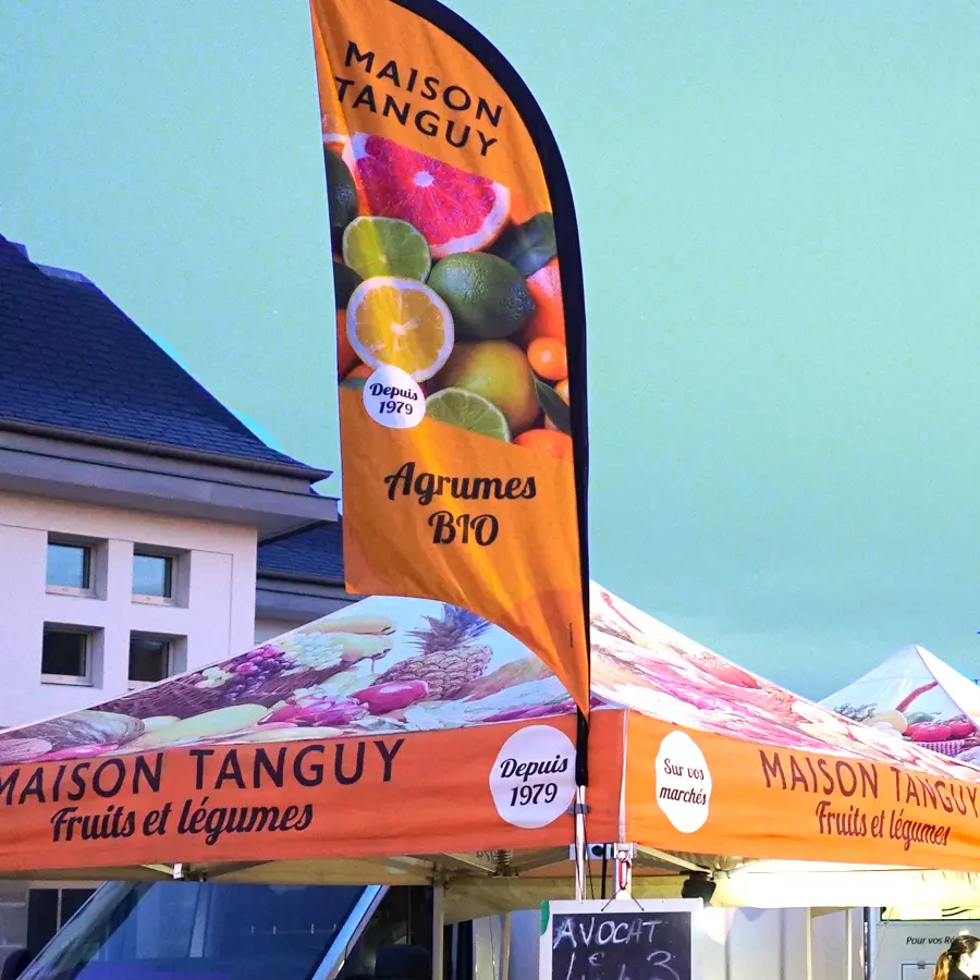 Oriflamme personnalisée aux couleurs de la Maison Tanguy accrochée au toit du barnum en extrémité de stand