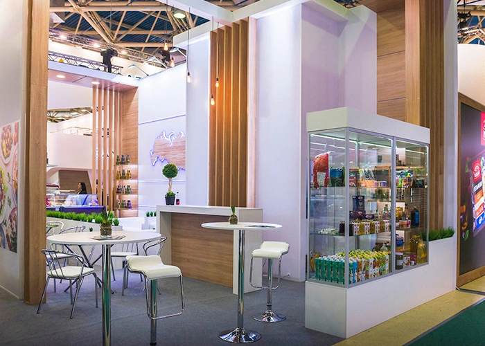 Stand de salon intérieur éclairé mettant en valeur les produits exposés et les comptoirs de discussion